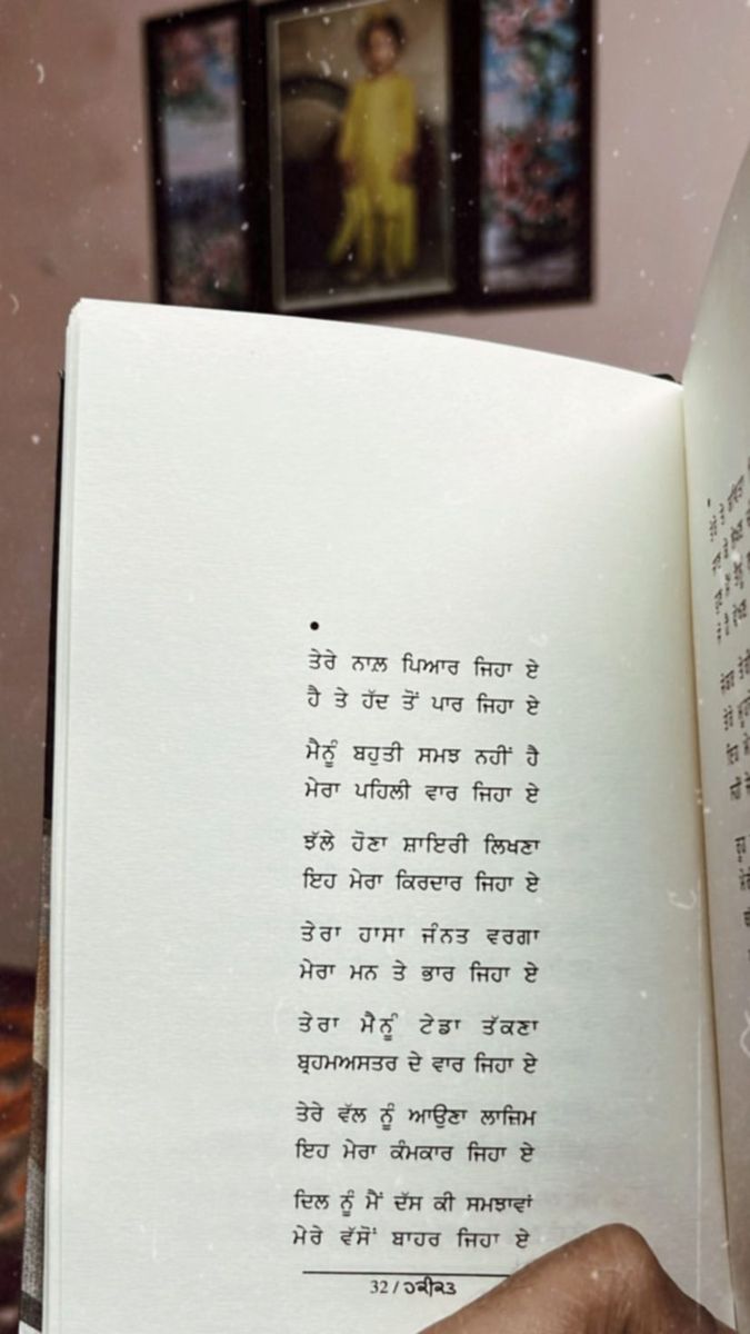 someone is holding an open book in front of their face and the pages are written in two different languages