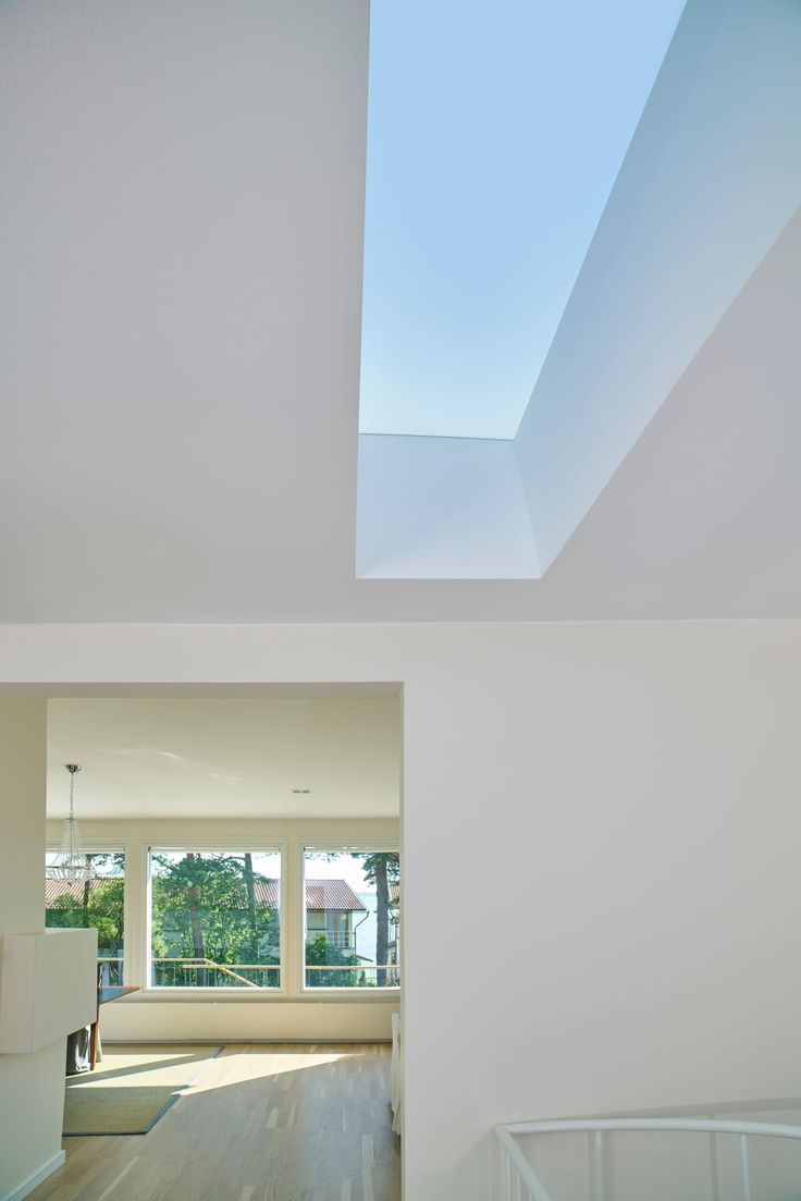 the interior of a house with skylights and hardwood floors in front of white walls