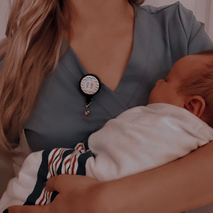 a woman holding a baby in her arms and wearing a watch on it's wrist