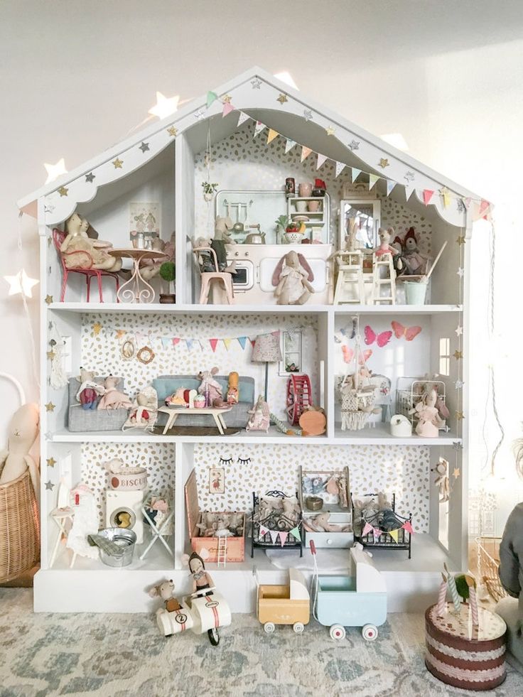 a doll house with lots of furniture and decorations on the shelves in front of it