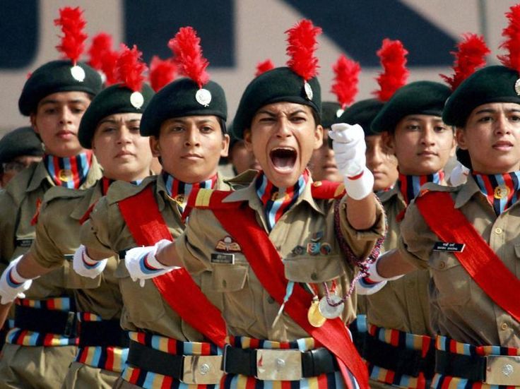 women in uniform are marching with their hands up