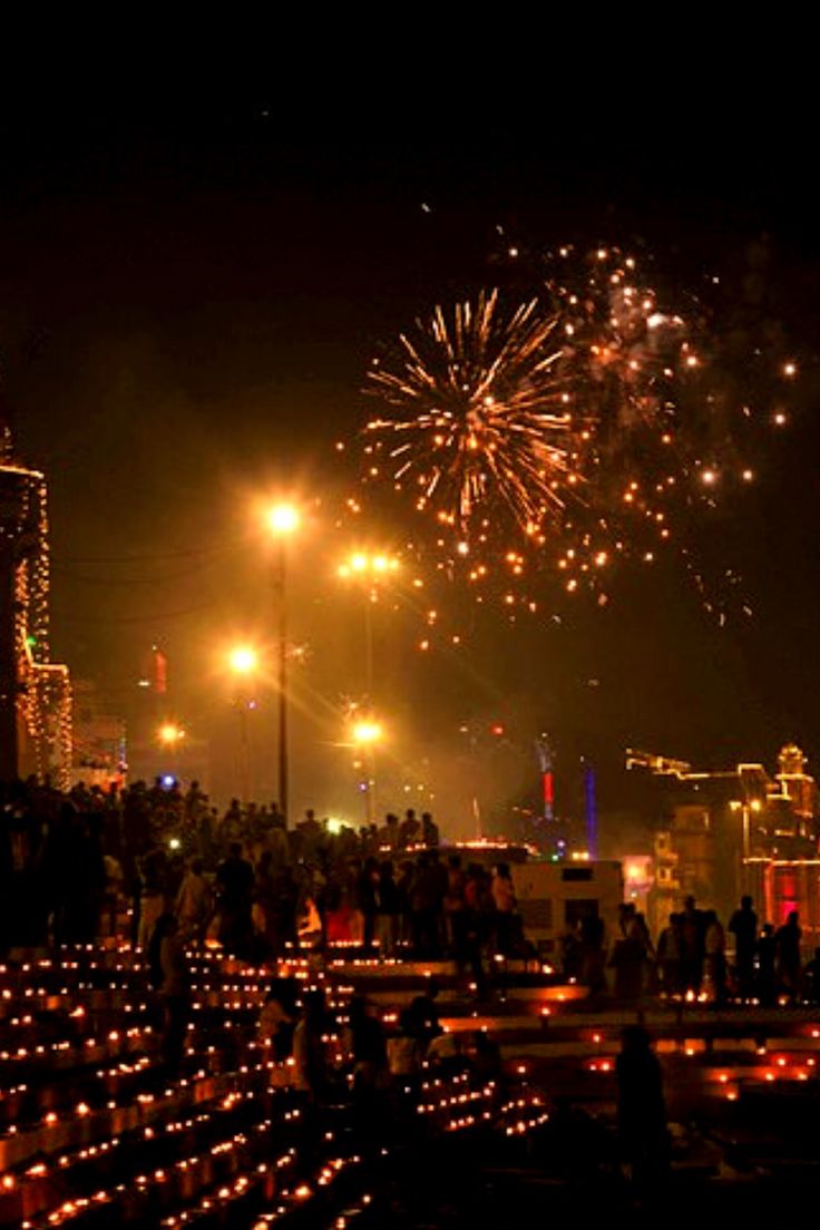 fireworks are lit up in the night sky over a city with lots of lights on it