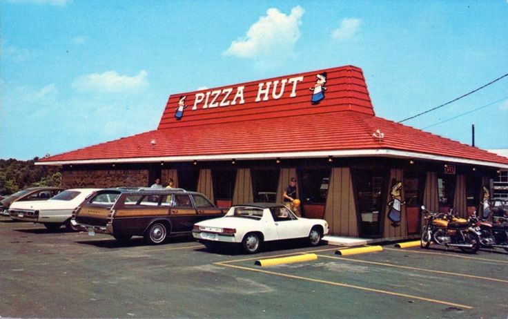 a pizza hut with cars parked in front of it