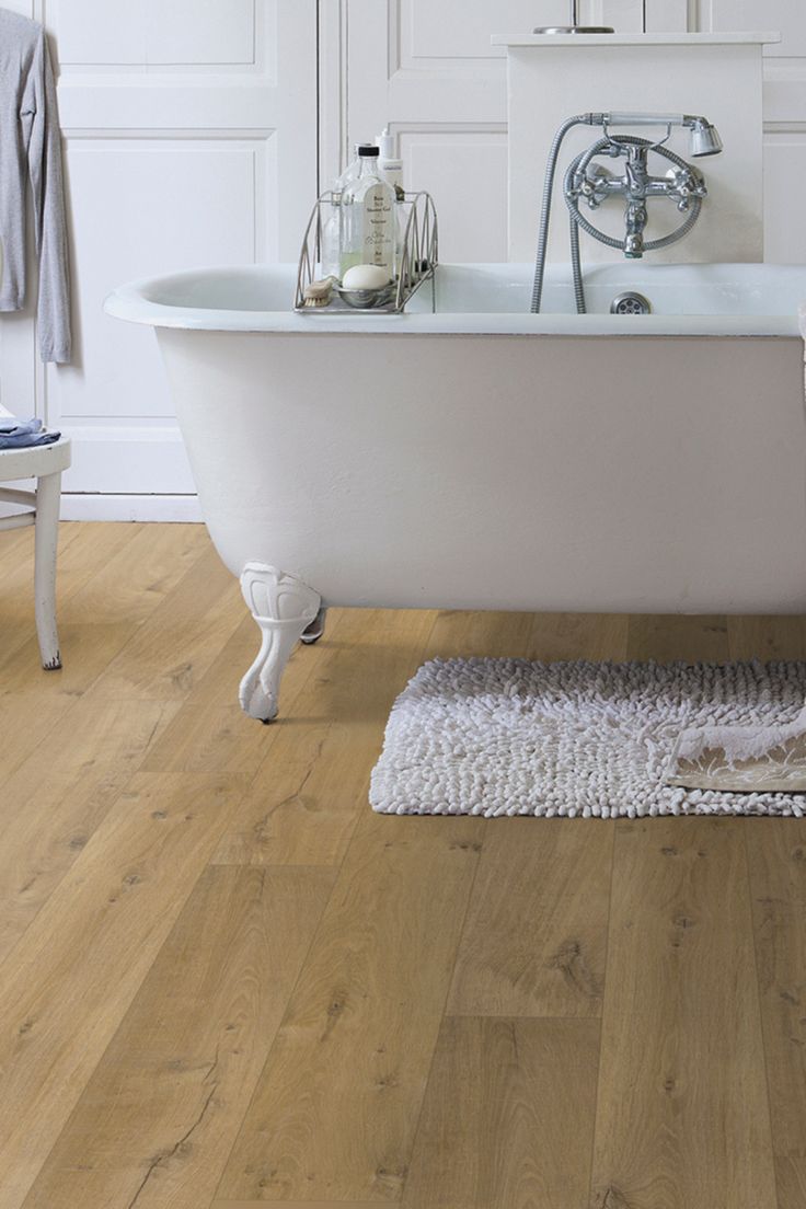 a white bath tub sitting on top of a wooden floor