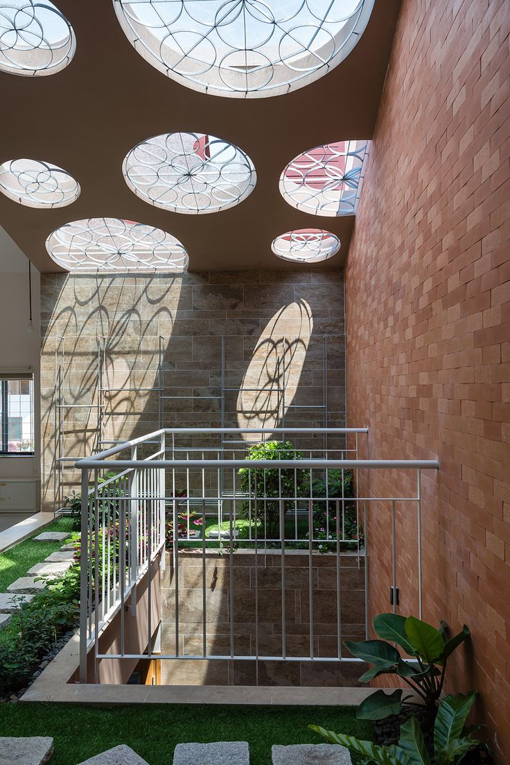 the inside of a building with lots of windows and grass on the ground below it