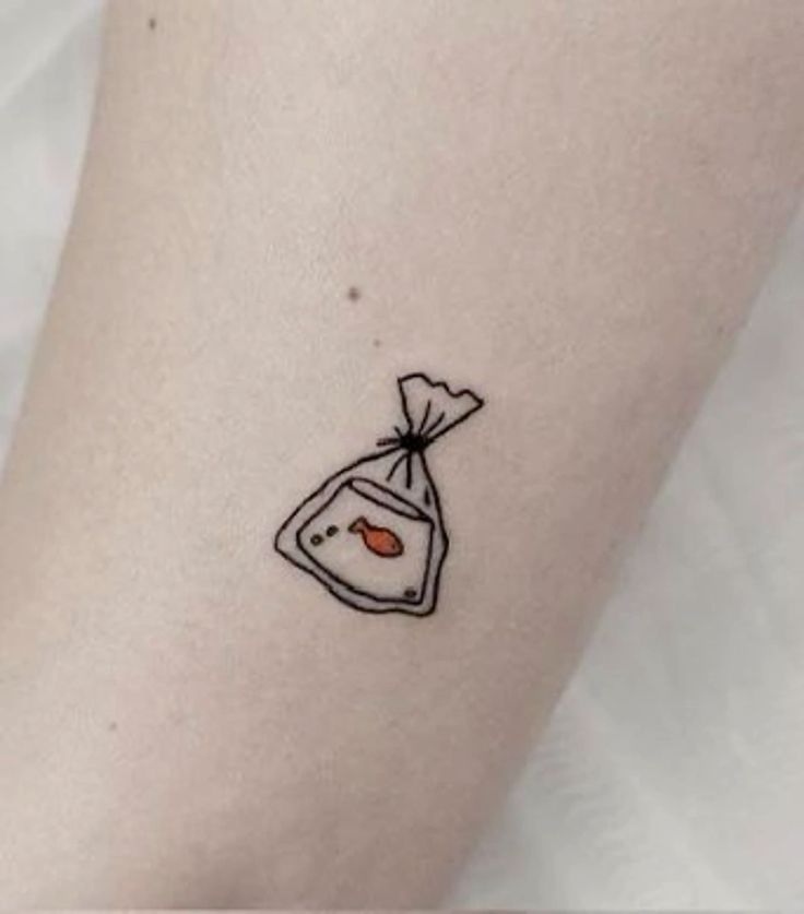 a small tattoo on the arm of a woman with a bag and fish in it