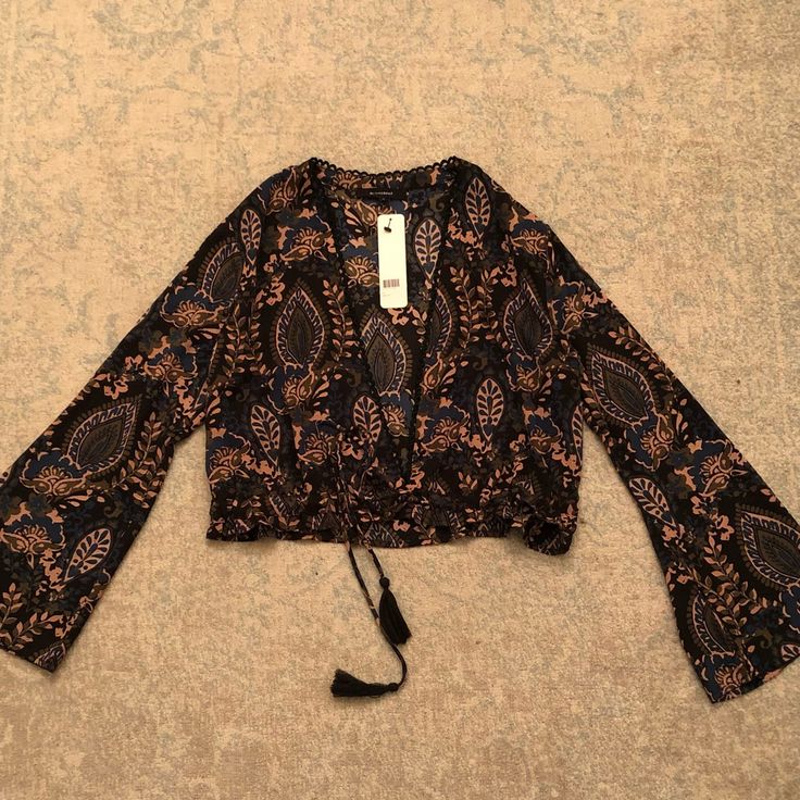 Boho Printed Deep V-Neck Blouse With Bell Sleeves And Adjustable Drawstring Waistline. Worn Best With A Bralette Or Bandeau. New With Tags, Never Worn. Festival Floral Print V-neck Top, Chic V-neck Festival Tops, Black V-neck Blouse For Beach, Trendy V-neck Top For Festivals, Black V-neck Printed Blouse, V-neck Festival Tops For Fall, Bohemian V-neck Top For Night Out, Black Long Sleeve Crop Top For The Beach, Bohemian V-neck Floral Print Crop Top