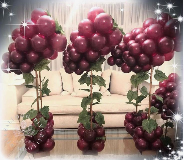 a bunch of balloons are hanging from the ceiling in front of a couch and table