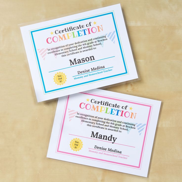 two certificates sitting next to each other on top of a wooden table with paper