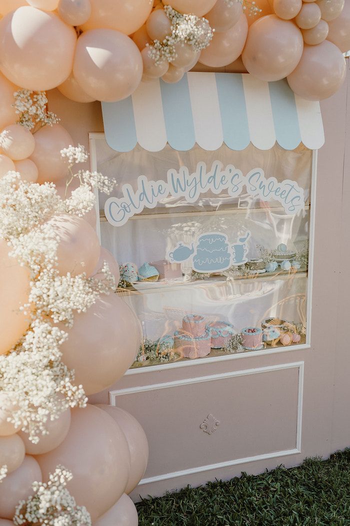 an ice cream stand decorated with balloons and baby's breath