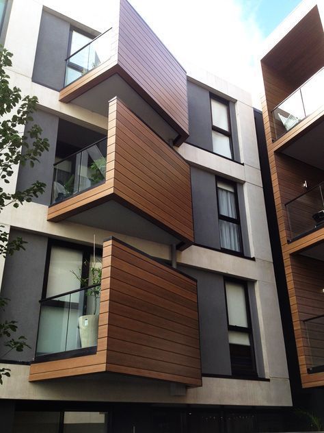 an apartment building with wooden balconies and windows