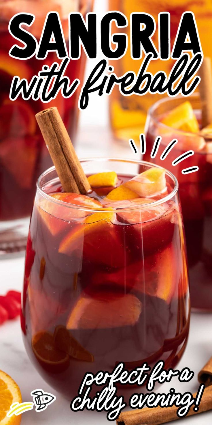 sangria with fireball recipe in a glass on a white table next to sliced oranges and cinnamon sticks