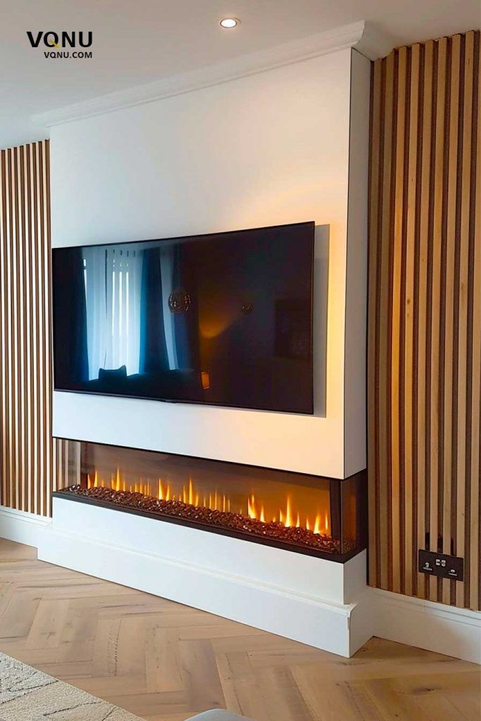 a living room with a large tv mounted on the wall and a fire place in front of it