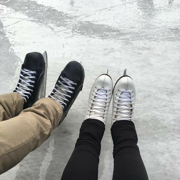 two people wearing black and white shoes standing next to each other with their feet in the snow