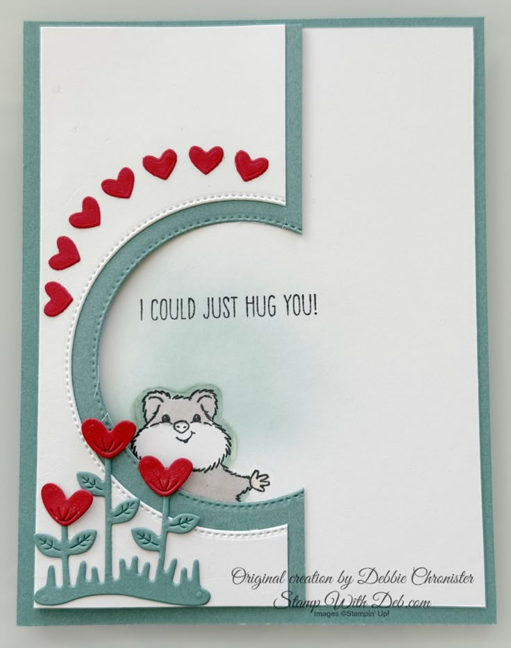 a handmade card with an animal and hearts on it's side, which reads i could just hug you