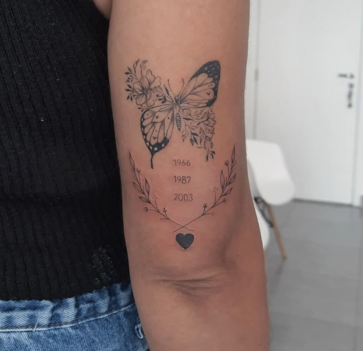 a woman's arm with a butterfly tattoo on the left side of her arm