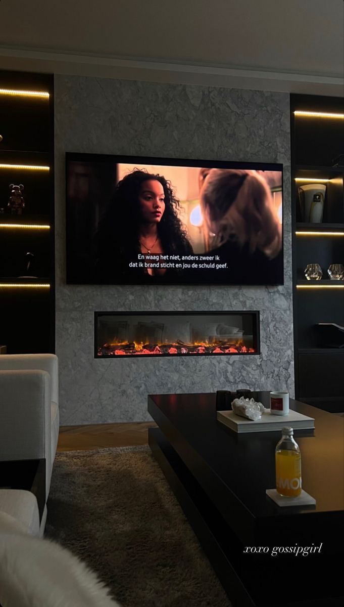 a flat screen tv mounted on the wall in a living room next to a fire place