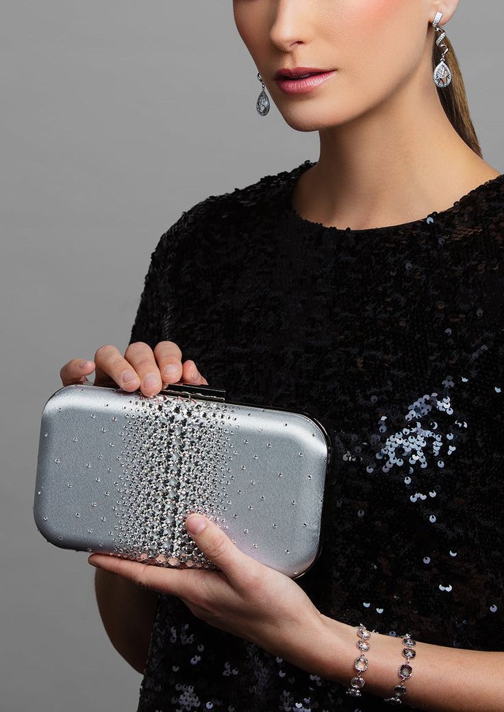 Add a hint of sparkle with this glamorous satin clutch — ELLA is adorned with the highest quality brilliant cut crystals to add the perfect touch of sparkle to any look. Perfect for pairing with a vibrant evening gown to bring out its designs, the Ella Crystal Clutch is a beautiful evening wear clutch with just enough detail to make the accents of your dress shine. Against a smooth and soft satin background layer are clear, sparkly crystals that are heavy in concentration and large in the center Elegant Rectangular Sequin Clutch, Luxury Embellished Clutch For Cocktails, Embellished Rectangular Clutch For Cocktail, Rectangular Embellished Clutch For Cocktail, Silver Crystal Embellished Evening Bag For Cocktail, Glamorous Rhinestone Evening Bag For Cocktails, Silver Crystal Embellished Cocktail Evening Bag, Chic Rhinestone Evening Bag For Cocktail, Luxury Embellished Evening Bag For Cocktail