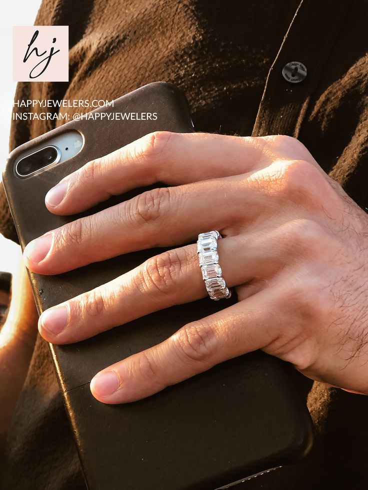 a man's hand holding an iphone case with a diamond ring on it,