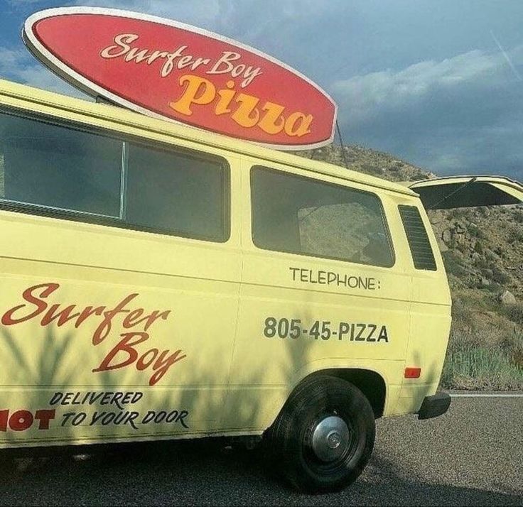 a yellow van with surf board on top