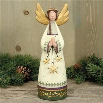 an angel figurine sitting on top of a wooden table next to pine cones