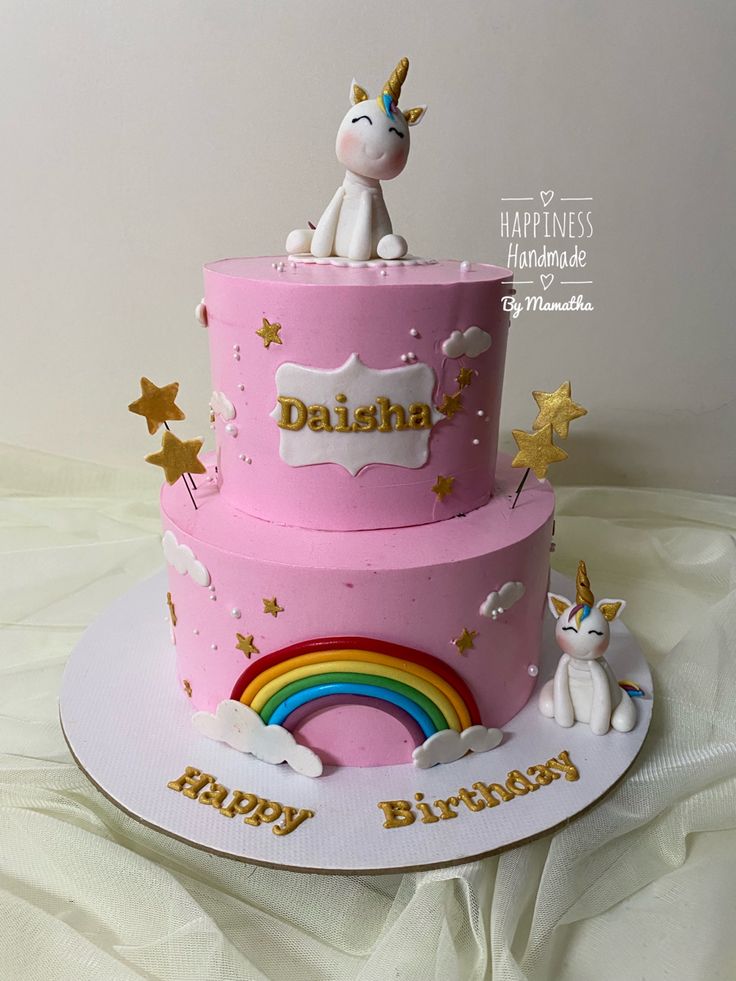 there is a pink birthday cake with a unicorn on top