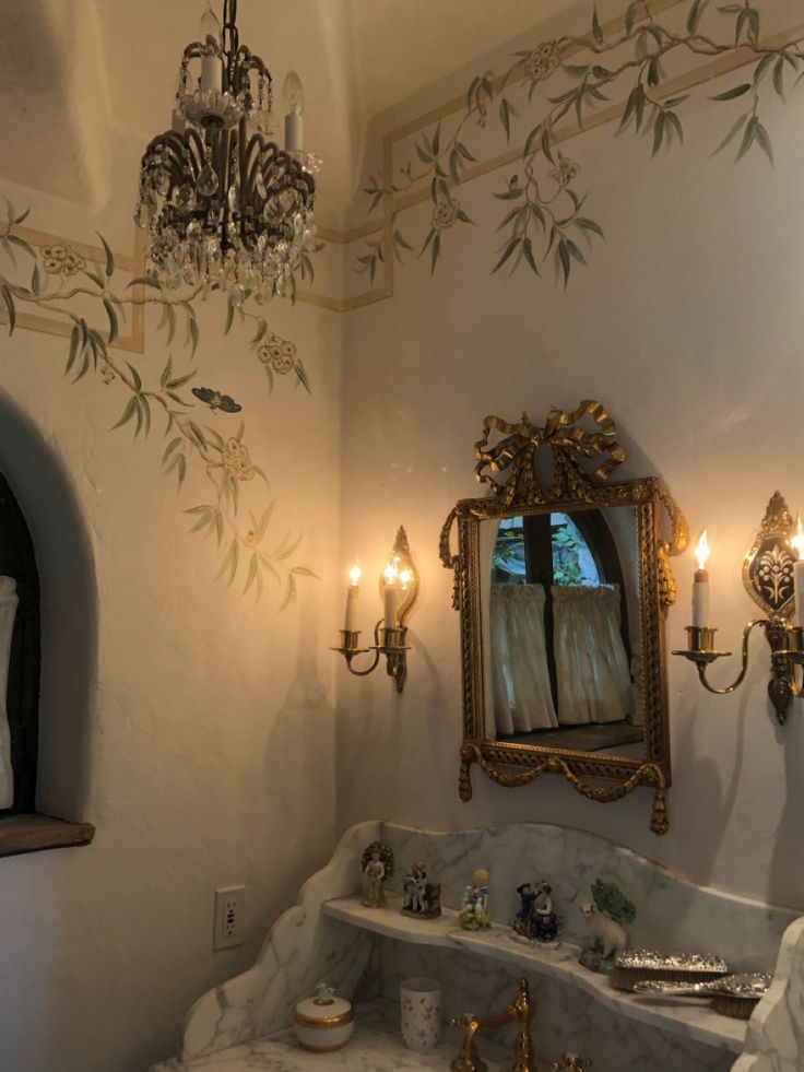 a fancy bathroom with chandelier, mirror and sink in it's corner