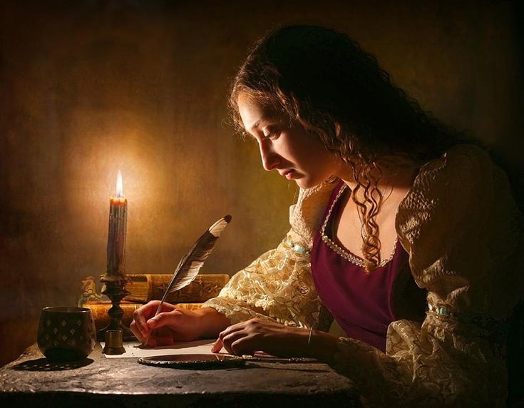 a woman sitting at a table writing in front of a lit candle with a feather quill on it