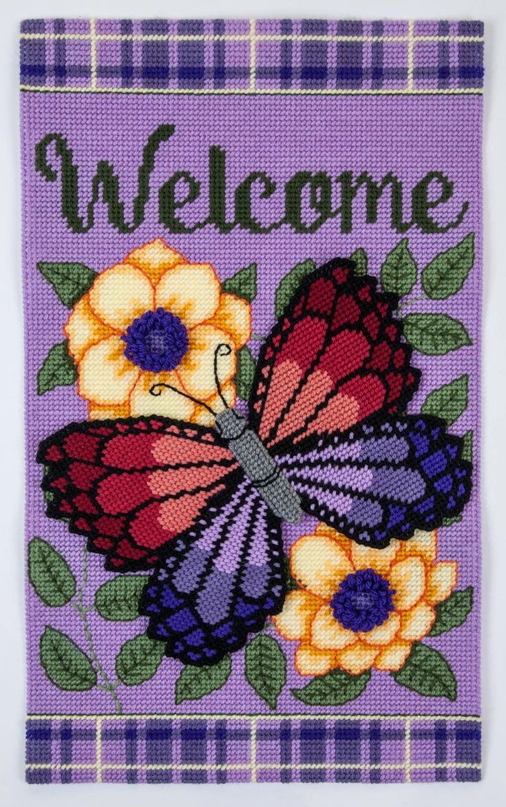 a welcome sign with flowers and a butterfly on the front, sitting on a purple background