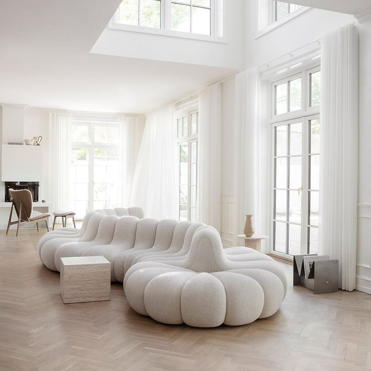 a living room with white furniture and large windows