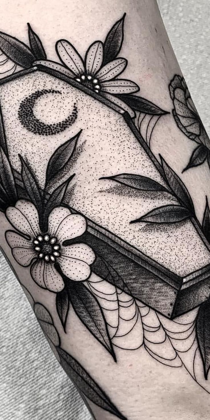 a black and white tattoo with flowers on it