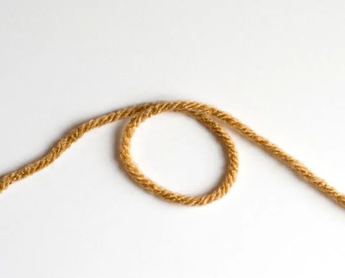 a piece of rope that is on the ground next to a white wall and floor