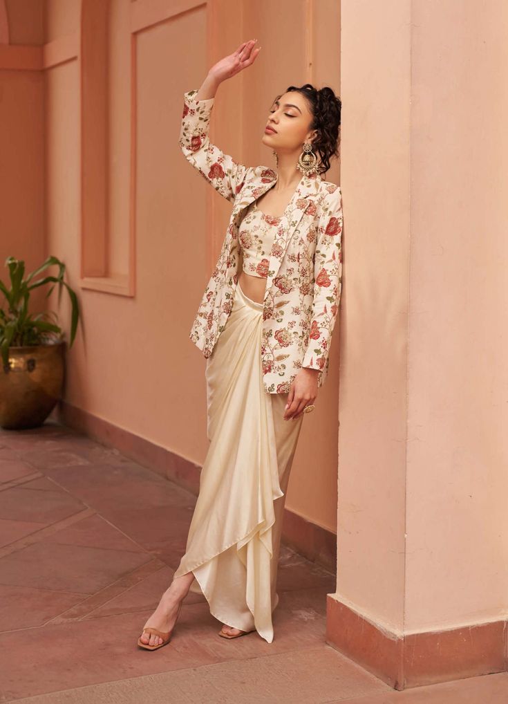 Introducing this stunning embroidered jacket ensemble, paired elegantly with an embroidered inner layer and a draped satin skirt. This ensemble exudes sophistication and grace, making it perfect for any special occasion where you want to make a lasting impression. Elevate your style with this timeless and elegant outfit. Draped Sets With Floral Embroidery In Georgette, Festive Draped Sets With Floral Embroidery, Elegant Floral Embroidery Pre-draped Saree, Elegant Draped Dress With Zari Work, Embroidered Draped Sets For Wedding, Draped Embroidered Party Set, Embroidered Draped Party Set, Formal Embroidered Silk Pre-draped Saree, Elegant Long Sleeve Pre-draped Saree With Zari Work