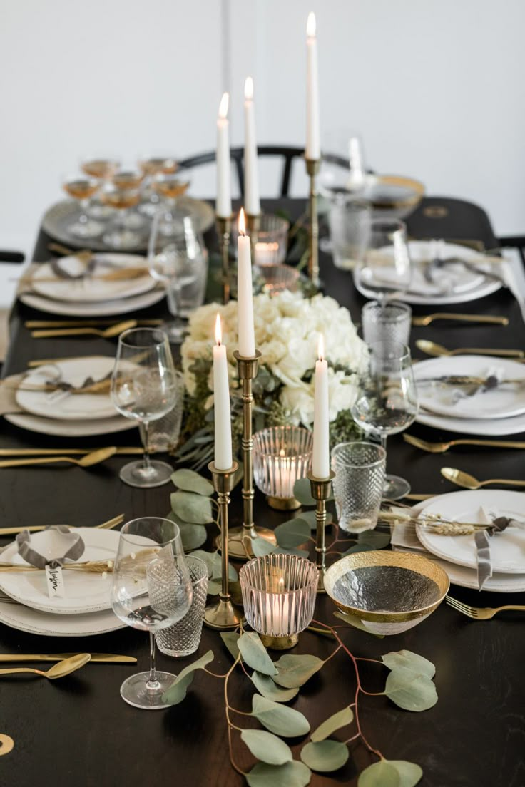 the table is set with candles, plates and silverware