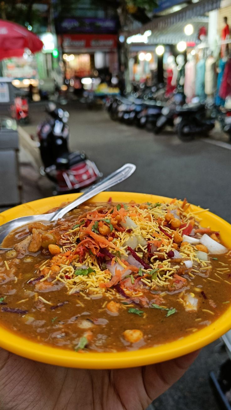 a person holding a yellow bowl filled with food