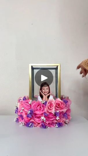 a photo frame sitting on top of a table with pink flowers in front of it