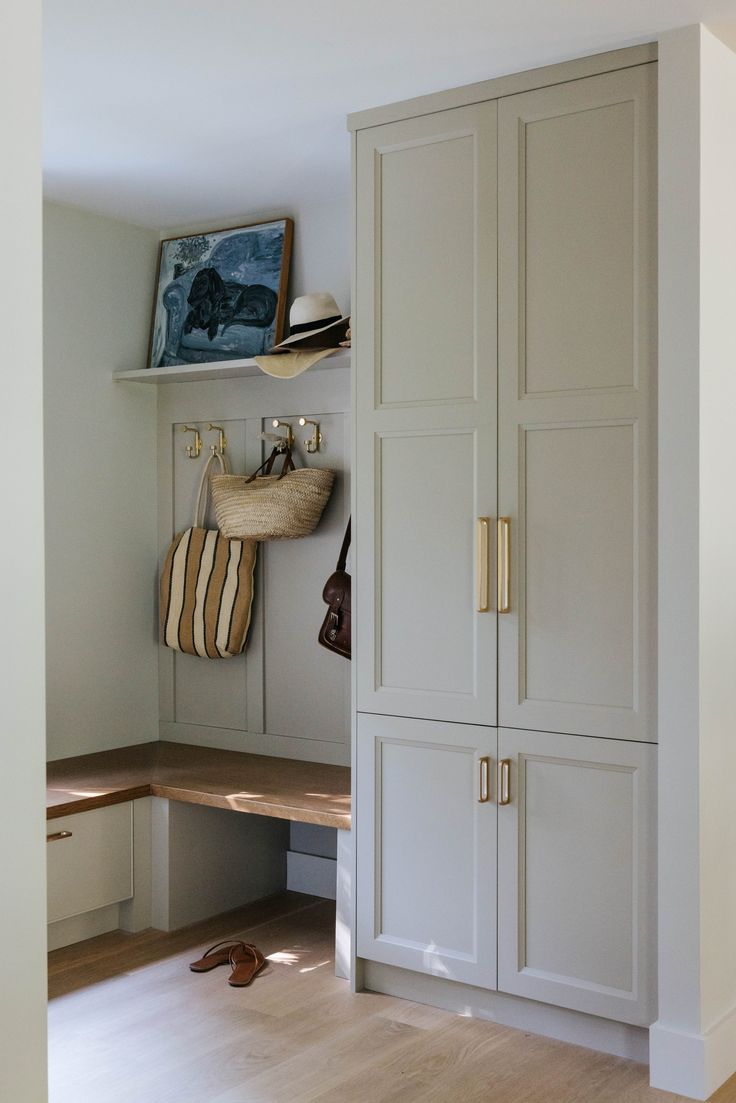 a white closet with some shoes on the floor and a hat hanging from it's door