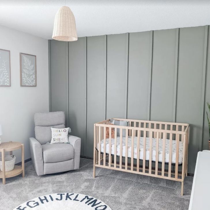 a baby's room with grey walls and white furniture