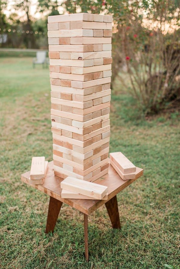 a wooden tower made out of blocks in the grass