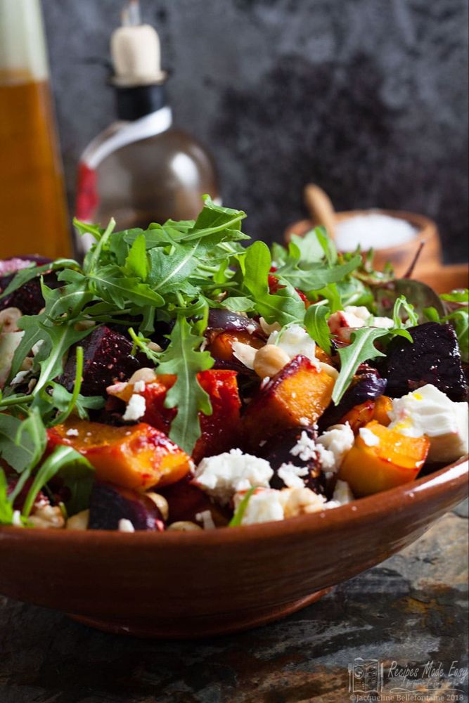 a close up of a salad in a bowl on a table with other plates and utensils