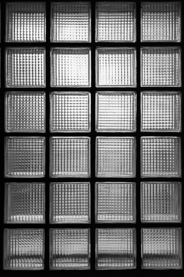 a black and white photo of square glass blocks on the wall in an office building