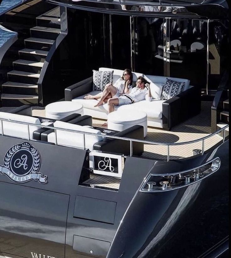 two people lounging on the back of a boat