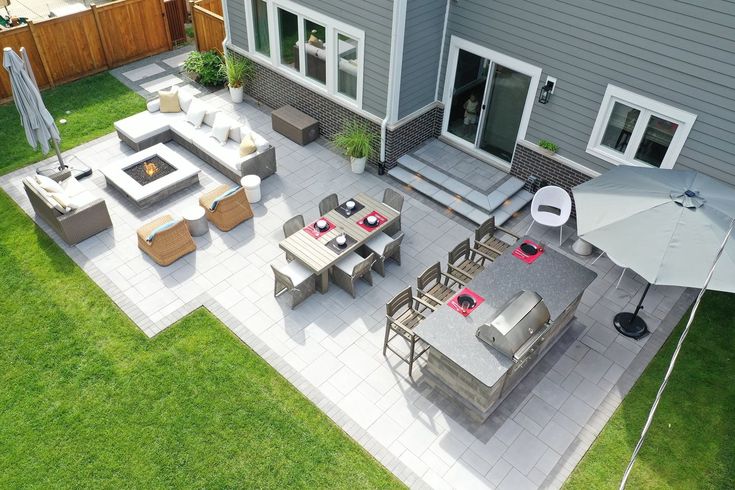 an aerial view of a patio with tables and chairs, umbrellas and fire pit