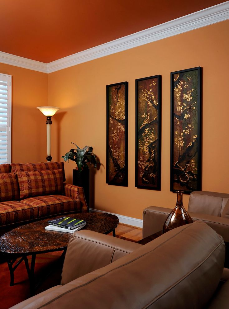 a living room with couches and paintings on the wall