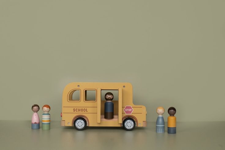 a school bus with people standing in front of it on top of a gray surface