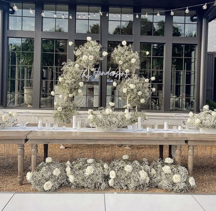 a table with flowers and candles on it in front of a building