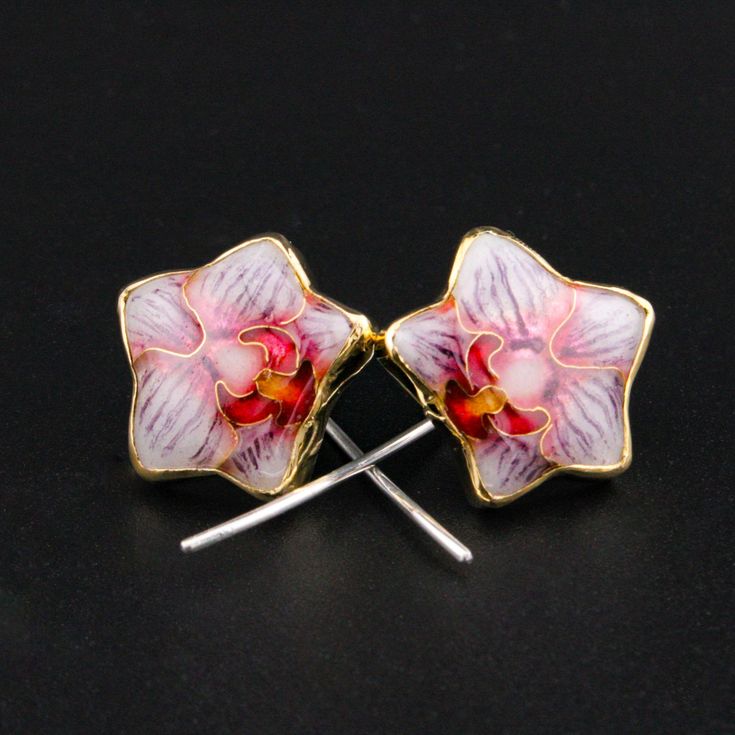 Orchids are often a symbol of love, beauty, refinement, many children, thoughtfulness and mature charm. These earrings are inspired by the delicate bloom of orchids. The enamel is made using glass, fine silver and 24k gold while the settings is a mixture of 22kgold and sterling silver. These earring are a long stem post that is both delicate and lightweight. Delicate and elegant, these earrings are perfect for the minimalist and garden lover in your life. Measurements: .6" H x .6 W Gold Enamel Earrings With Flower Charm, Gold Earrings With Flower Charm In Enamel, Gold Earrings With Flower Charm And Enamel, Handmade Orchid Earrings, Gold Enamel Flower Earrings, Elegant Orchid Flower Earrings, Yellow Gold Enamel Earrings As Gift, Elegant Hand Painted Gold Jewelry, Elegant White Hand-painted Jewelry