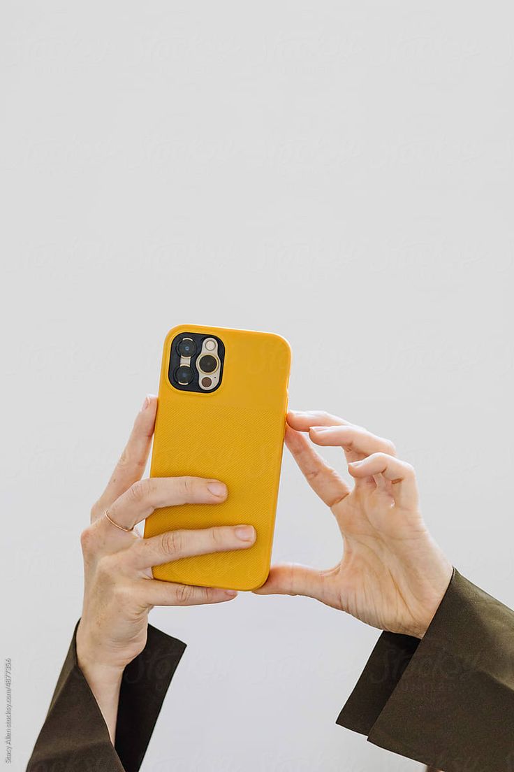 two hands holding up a yellow case to show the back of an iphone 6s