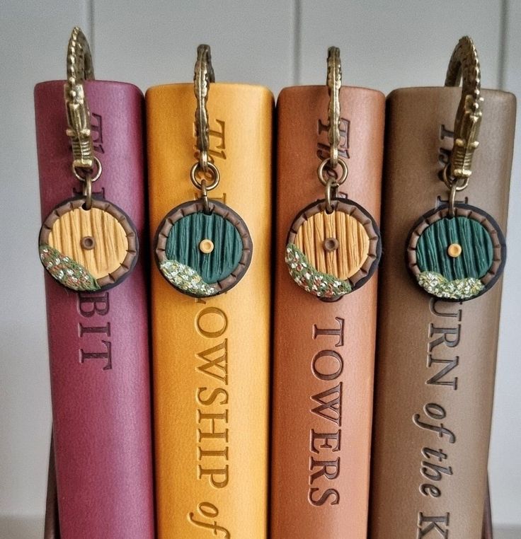 four books with keychains on them sitting in front of the same bookcase