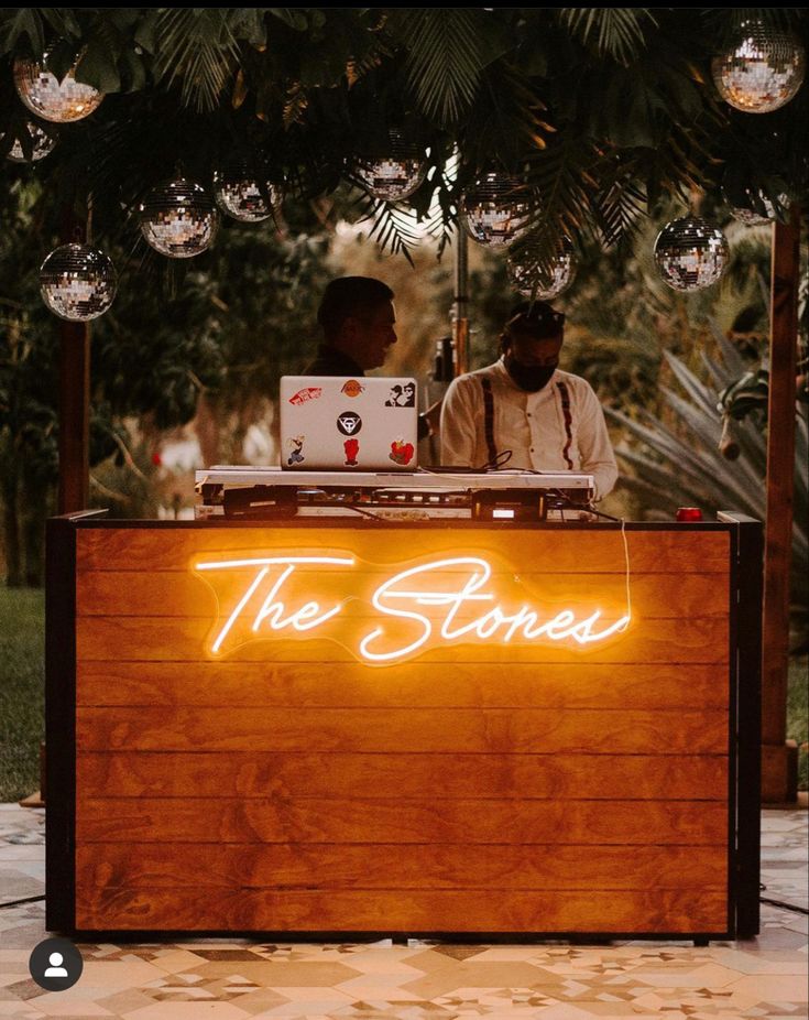 a man and woman standing behind a counter with the words the stones written on it